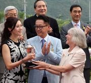 Mrs Sheila Ip, wife of Dr Simon S O Ip, Chairman of the Hong Kong Jockey Club, presents the Kwangtung Handicap Cup to the winning Owner Julian Hui and Michele Reis.
