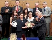 Chairman of the Oriental Watch Holdings Limited Dr Yeung Ming Biu, accompanied by his wife, presents a souvenir to the owner representative of Military Attack.