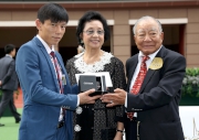 Chairman of the Oriental Watch Holdings Limited Dr Yeung Ming Biu, accompanied by his wife, presents a prize of HK$2,000 and a delicate watch to the Stables representative responsible for Designs On Rome, the Best Turned Out Horse in the Oriental Watch Sha Tin Trophy.