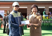 Before the race, Carrie Lam, Chief Secretary for Administration of the HKSAR, presents a prize of HK$1,500 and a 130th anniversary souvenir to the stables assistant responsible for Let Me Go, the best turned out horse of The Hong Kong Jockey Club 130th Anniversary Cup.