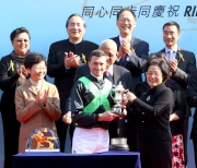 Tong Xiaoling, Deputy Commissioner of the Ministry of Foreign Affairs of the People's Republic of China in the HKSAR, presents a trophy to winning jockey Douglas Whyte.