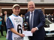 Mr Kevin Coon, Vice President of BMW Group Importer Office Hong Kong, Macau & Taiwan, presents a prize and a souvenir to the stables assistant responsible for REDKIRK WARRIOR, the best turned out horse in the BMW Hong Kong Derby, in the Parade Ring before the race.