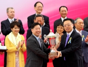 澳門賽馬會執行董事兼行政總裁李柱坤先生（右）頒發澳港盃獎盃予頭馬「夢仙」的練馬師葉楚航。