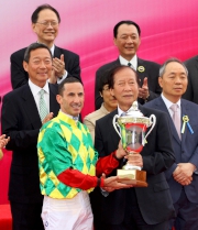 澳門賽馬會董事李惠文先生（右）頒發澳港盃獎盃予頭馬「夢仙」的騎師杜利萊。
