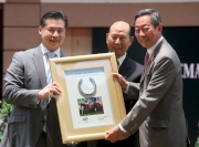 Owners Mr Johnson Lam Pui Hung (centre)  and Mr Anderson Lam Hin Yue (left)  present a framed Ambitious Dragon horseshoe to the Hong Kong Jockey Club Chairman Dr Simon Ip (right). 