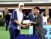 Permanent Secretary for Food and Health Mrs Cherry Tse presents the Best Turned Out Horse award to the winning stables assistant of Savvy Nature. 