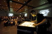 Lee Sai-ho, an artist with ASD, showcases his talent in sand drawing performance at the JC A-Connect: Jockey Club Autism Support Network launch ceremony. 