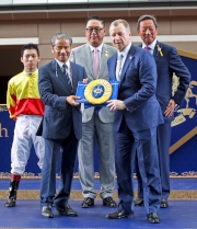 香港賽馬會行政總裁應家柏致送紀念綵帶予練馬師告東尼。