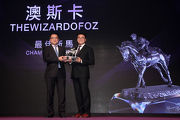 Mr Carlos Wu, Chairman of the Association of Hong Kong Racing Journalists, presents the trophy to Mr Martin Siu Kim Sun, owner of Champion Griffin Thewizardofoz. 