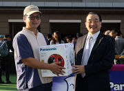 Mr Terrence Chan, Vice Chairman of Shun Hing Group, presents a prize of HK$1,500 and a Panasonic Ball Fan to the Stables Assistant responsible for Blizzard, the best turned out horse in the Panasonic Cup.