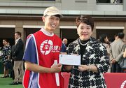 Mrs Kamill Fung Yin Fan, Deputy General Manager, Channel Management of Bank of China (Hong Kong) Limited, presents a HK$2,000 prize to the stables assistant responsible for Able Friend, the best turned out horse in the BOCHK Wealth Management Jockey Club Mile.
