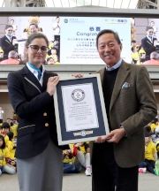 Photos 8, 9<br>
Club Chairman Dr Simon S O Ip (photo 8, right) receives a certificate from Guinness World Records adjudicator Joanne Brent (photo 8, left), after which he was joined by President of the Sports Federation & Olympic Committee of Hong Kong, China, Timothy Fok (photo 9, 7th right) ; Club Deputy Chairman Anthony W K Chow (photo 9, 6th left) and Executive Director, Corporate Business Planning & Communications Scarlette Leung (photo 9, 1st left); elite athletes and guests; and over 1,000 students to celebrate the production of the longest paper chain of cheering messages in the world. 
