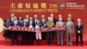 Dr Simon Ip, Chairman of the Hong Kong Jockey Club, Club Stewards, CEO Winfried Engelbrecht-Bresges, and the connections of race winner Chautauqua, smile for cameras in the Chairman��s Sprint Prize trophy presentation ceremony.