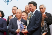 渣打銀行（香港）有限公司大中華及北亞地區行政總裁洪丕正（右），在頒獎禮上頒發紀念品予「將男」的馬主代表。