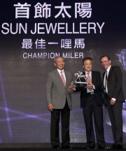 Mr Lester C H Kwok, Steward of The Hong Kong Jockey Club, presents the trophy to Tung Moon Fai, owner of Champion Miler Sun Jewellery, accompanied by trainer John Size. 