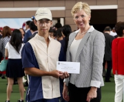 Dr Trisha Leahy, Chief Executive of the Hong Kong Sports Institute, presents a prize of HK$1,500 to the Stables Assistant responsible for Ambitious Champion, the Best Turned Out Horse in the Hong Kong Reunification Cup.
