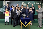 Mr. James C O Wong, Chief Executive Officer of Kwoon Chung Bus Holdings Limited, presents the trophy to winning trainer Peter Ho.