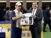 Mr Terrence Chan, Vice Chairman of Shun Hing Group (right), presents a prize of HK$1,500 and a Panasonic Slow Juicer to the Stable Assistant responsible for Mr Bogart, the best turned out horse in the Panasonic Cup.
