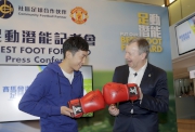 Rex Tso (left), one of the mentors of this year's Hong Kong Jockey Club Youth Football Development Programme, passes an autographed pair of his boxing gloves to Club Chief Executive Officer Winfried Engelbrecht-Bresges. The gloves will be presented to the best performing participant at the end of the programme.  