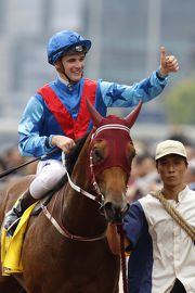 Sam Clipperton salutes after winning the Hong Kong Macau Trophy on the John Moore-trained Invincible Dragon.