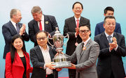 Mr. Paulo Martins Chan (right), Director of Gaming Inspection and Coordination Bureau of The Macao SAR Government, presents the trophy to Ming Shui Sum and Alice Ming Bo Ting, owners of race winner Romantic Touch.