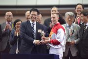 Zac Purton is presented with his trophy for winning the Class 3 18 Districts Cup Handicap (1200m) by Law King-Shing, the Duty Chairman of 18 District Councils and Chairman of Kwai Tsing District Council. It was also the rider��s 700th win in Hong Kong.