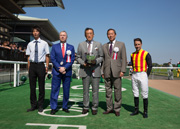 Hong Kong Jockey Club Chairman Dr. Simon Ip (second from right) and Chief Executive Officer, Mr. Winfried Engelbrecht-Bresges (second from left), present the trophy to Katsumi Yoshida (center), owner of Glengarry, winner of the Hong Kong Jockey Club Trophy.