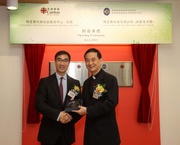 Jockey Club Steward Michael Lee (left) receives a souvenir from Caritas-Hong Kong Deputy Chief Executive Joseph Yim (right).