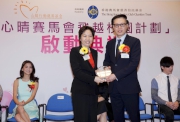 The Cluba?s Executive Manager, Charities, Florine Tang (left) receives a souvenir from the Foundationa?s Honorary President Simon To (right).