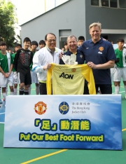 Mr Engelbrecht-Bresges (middle) and Lam Tai Fai College Supervisor Dr Lam Tai Fai (left) receive souvenirs - a pair of autographed goalkeeping gloves and a signed United jersey, respectively - from Schmeichel (right).
