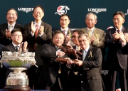 香港賽馬會主席施文信(右)頒發騎師駿馬銅像予「精彩日子」馬主百家樂團體的代表 。