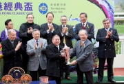 圖6、7、8:<br>
於賽後舉行的頒獎禮上,馬會董事郭志桁將冠軍獎盃及鍍金碟頒予香港經典盃頭馬「威爾頓」的馬主鄭強輝、練馬師約翰摩亞及騎師貝湯美。